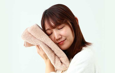 タオルの匂いを嗅ぐ女性